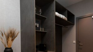 Una habitación moderna con escritorio integrado, estanterías y armario.