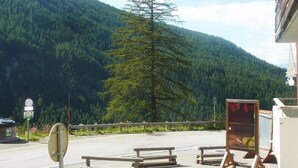 A mountain view with a wooden bench area, a signpost, and a glass display case. - Resort center, 1st floor, swimming pool, sauna, balcony, tv, ski locker, 50m², Les Orres (Les Orres)