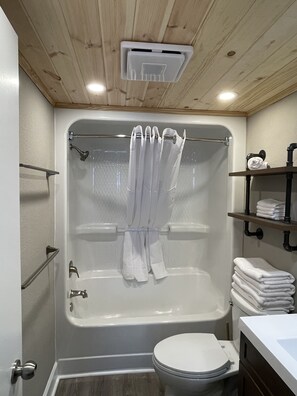 Une salle de bain avec une baignoire, des toilettes et un rideau de douche.
