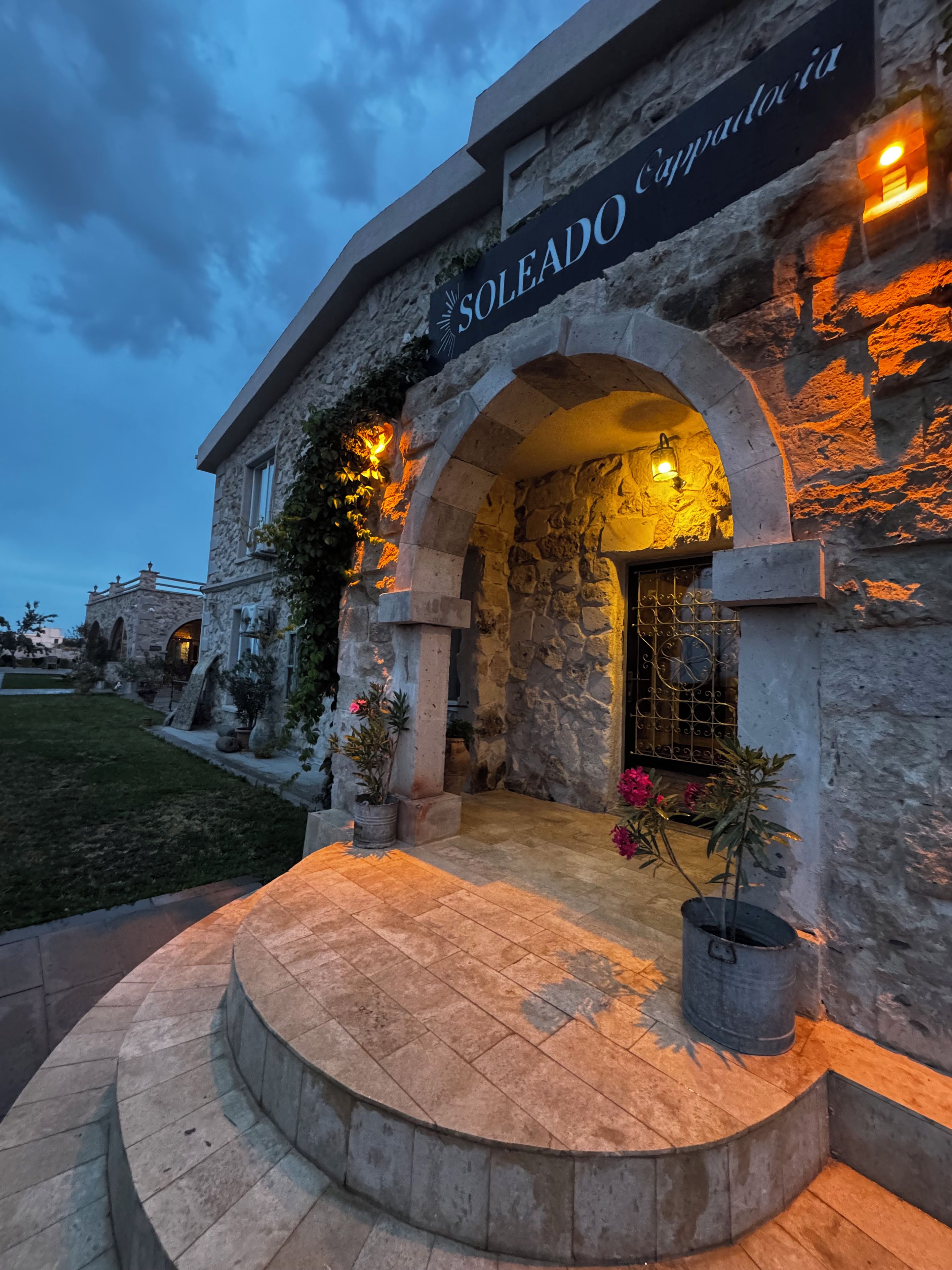 Un edificio de piedra con un letrero que dice 'SOLEADO Cappadocia' y una entrada en arco.