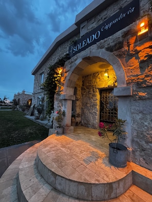 A stone building with a sign reading 'SOLEADO Cappadocia' and an arched entrance. - Soleado Capadocia Hotel (Nevsehir)