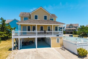 A two-story house with a covered porch and a garage.