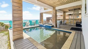 A wooden deck with a pool, outdoor seating, and a view of the ocean. - Gulf front retreat with pool, hot tub, & beach service—perfect for family groups (Panama City Beach)