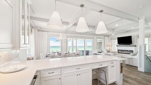 A spacious kitchen with a large island, pendant lights, and a view of the ocean. - Gulf front retreat with pool, hot tub, & beach service—perfect for family groups (Panama City Beach)