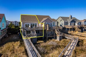 A coastal residential area with multiple houses connected by wooden walkways.