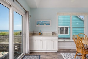 A coastal property with a kitchen, dining area, and a view of the sea.