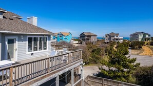 A coastal residential area with houses featuring balconies and a clear view of the ocean. - Tidy Duck-Semi-oceanfront with views, private pool, hot tub, steps to the beach! (Duck)