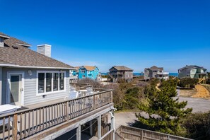 A coastal residential area with houses featuring balconies and a clear view of the ocean. - Tidy Duck-Semi-oceanfront with views, private pool, hot tub, steps to the beach! (Duck)