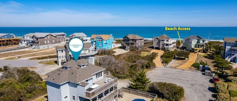 Una comunidad costera con acceso a la playa, que cuenta con edificios residenciales y una gran piscina.
