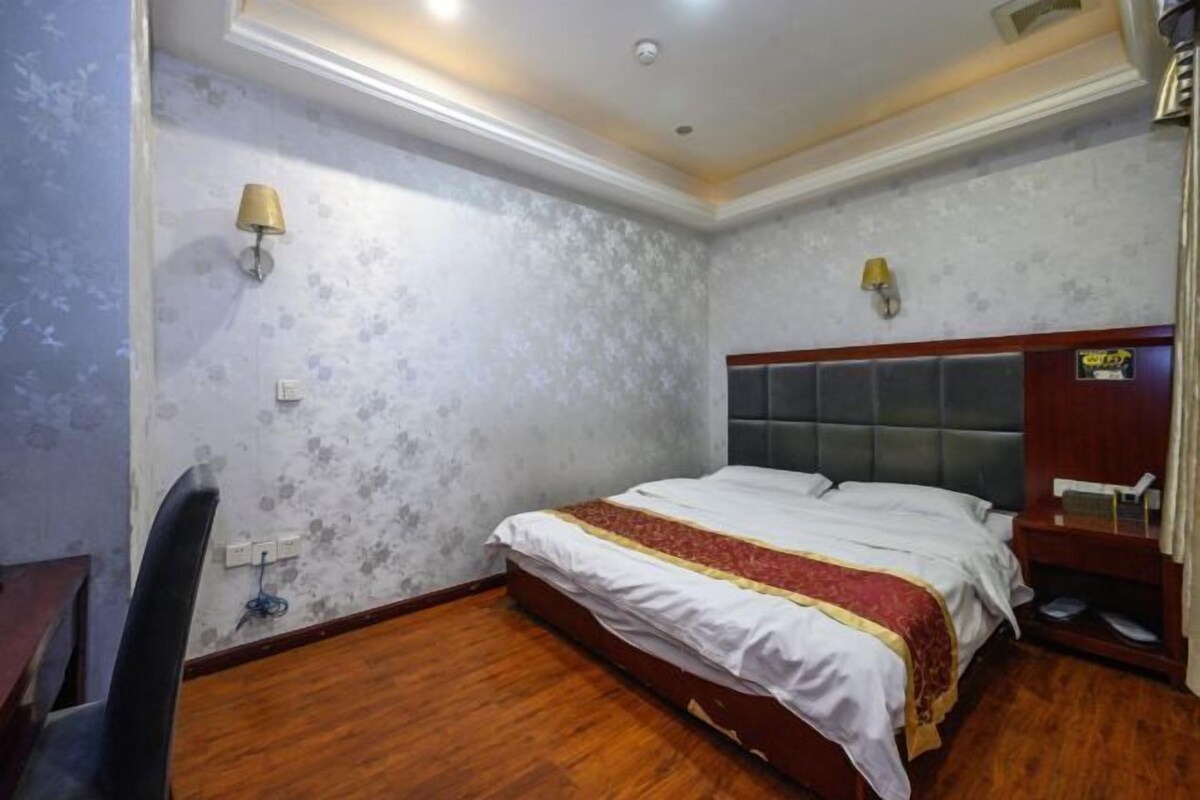 Una habitación de hotel con una cama, un escritorio y una silla.