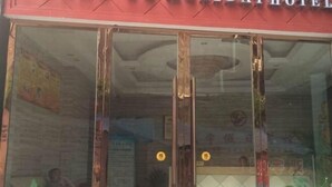 The exterior of a Holiday Hotel with a red awning and large glass doors. - Nanjiang Shuangyu Holiday Hotel (Nanjiang)