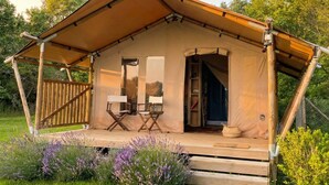 A tented accommodation with a covered porch, two folding chairs, and a door leading inside. - Tenuta San Lodovico (Scansano)