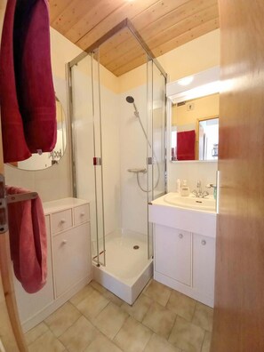 A bathroom with a glass-enclosed shower, a white sink, and a mirror. - 200m from resort center, 2nd floor, balcony, tv, ski locker, 45m², Champagny-en-Vanoise (Champagny-en-Vanoise)