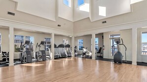 A spacious gym with multiple treadmills, elliptical machines, and a stationary bike. - Whispering Sound: Waterfront | Pool/Gym Access (Manteo)