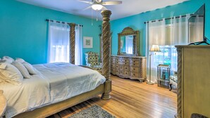 A bedroom with a bed, a ceiling fan, a dresser, a chair, and a mirror. - Pet-Friendly Fort Valley Home w/ Private Pool (Fort Valley)