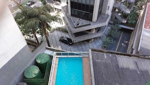 Una piscina en la azotea con vistas a los edificios y la calle circundantes.