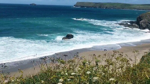 A coastal landscape with a beach, ocean waves, and a distant island. - A stunning Cornish barn, ideally located for visiting the North and South Coast. (Altarnun)