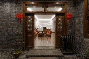 A traditional wooden entrance with a modern interior visible through the doorway. - Wangjiang Shanju Guesthouse (Fenghuang County)