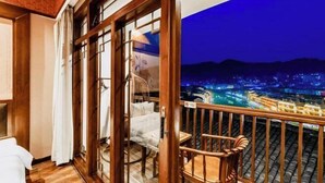 A balcony with a view of a cityscape at night. - Wangjiang Shanju Guesthouse (Fenghuang County)