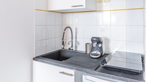 A kitchen with a black sink, a Bosch coffee maker, and a toaster. - Le Guindy - Localisation idéale (Treguier)