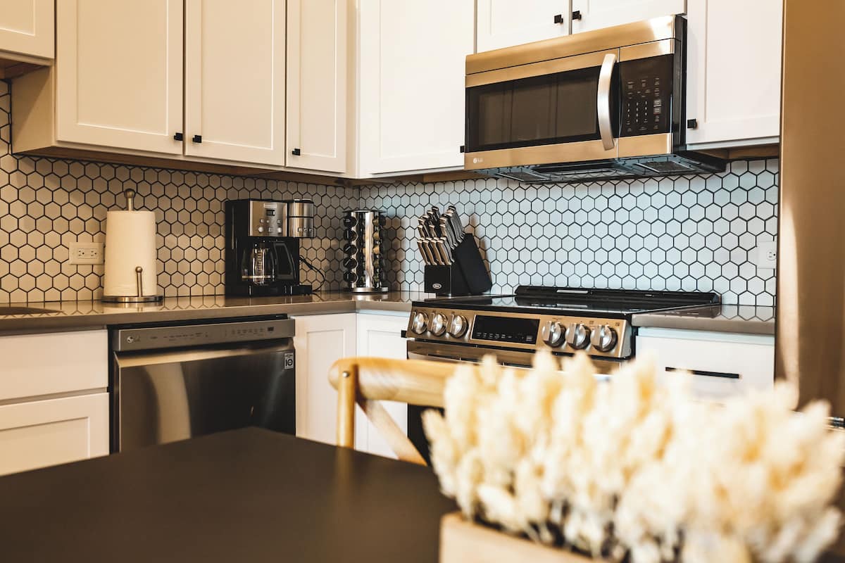 Een koelkast met diepvriezer, een microgolfoven, een oven, een kookplaat