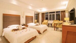 A hotel room with two beds, a desk, a chair, and a TV. - Beichen Hotel (Haikou)