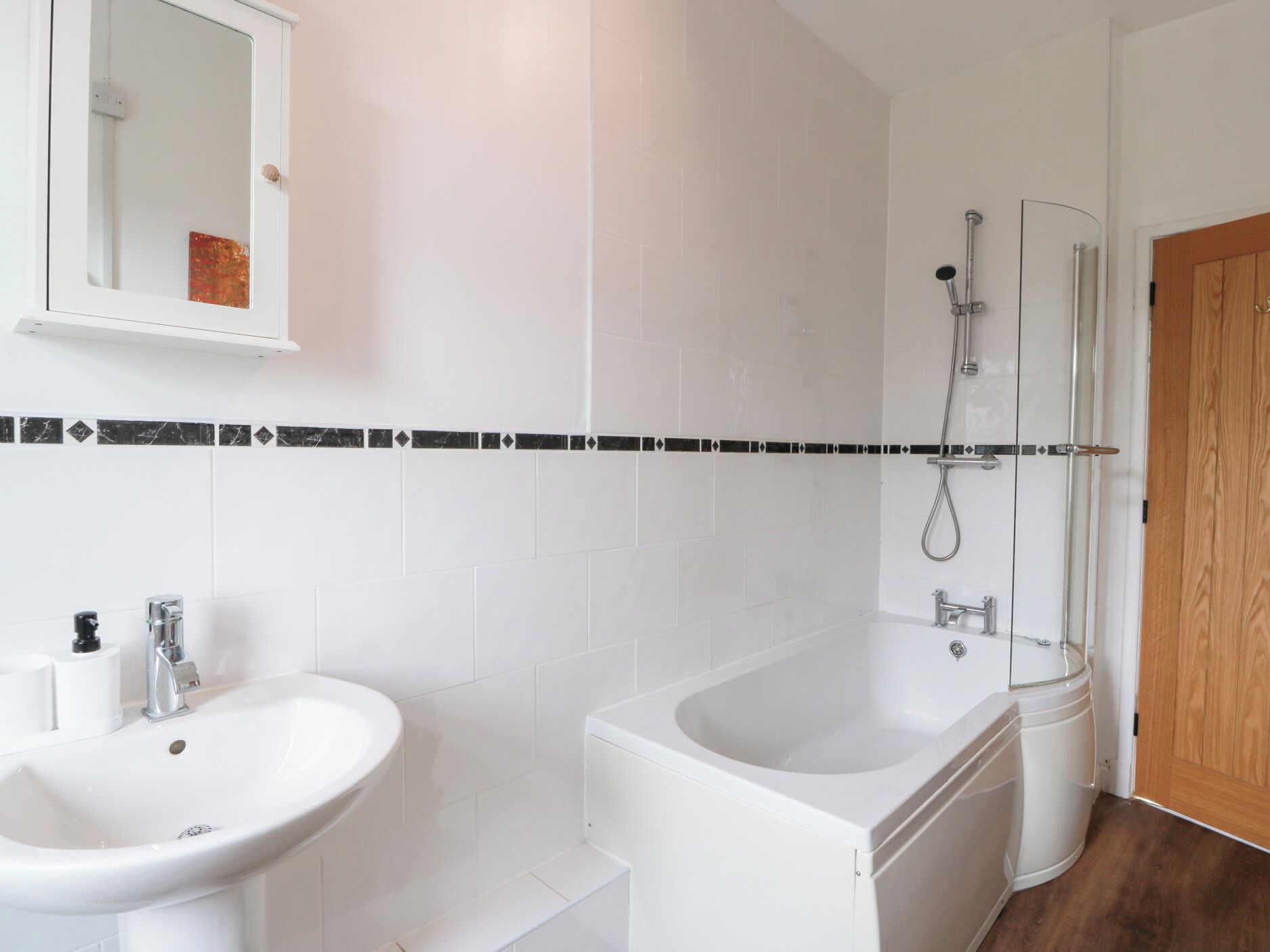 A modern bathroom with a white sink, a bathtub, and a shower.