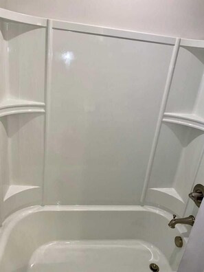 A white bathtub with a single faucet and a drain.