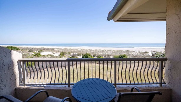 Un balcon avec vue sur une plage et l’océan.