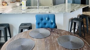 A modern kitchen with blue cabinets, a marble countertop, and a unique geometric pendant light. - River Rendezvous! Newly renovated with newly  constructed boathouse (Matagorda)