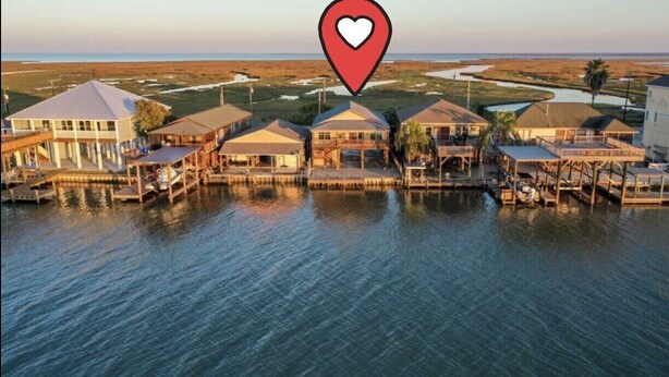 A waterfront property with multiple houses connected by docks, a marina, and a view of the ocean. - River Rendezvous! Newly renovated with newly  constructed boathouse (Matagorda)