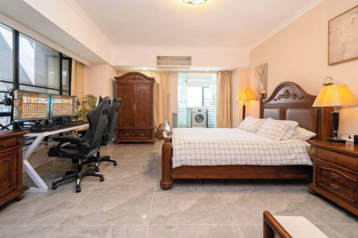 Une chambre à coucher avec un lit, un bureau, une chaise et une fenêtre.