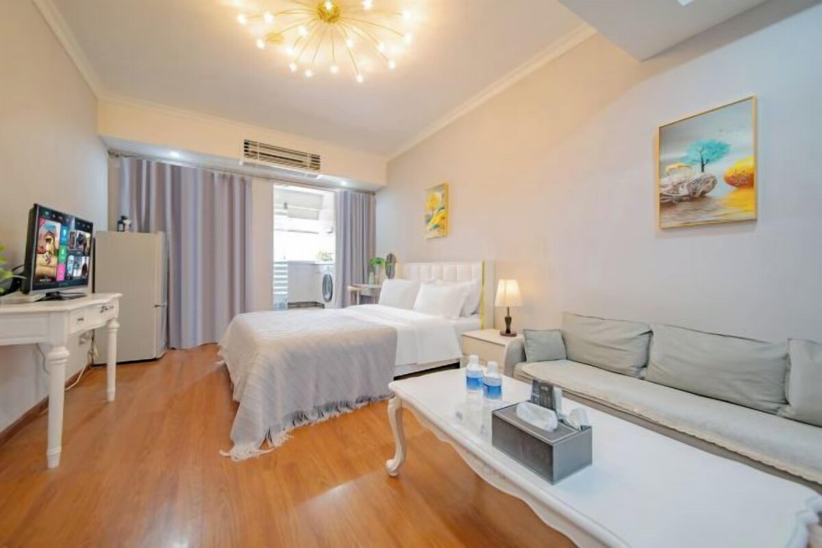 Una habitación de hotel con una cama, un sofá, un escritorio con una computadora y un televisor.