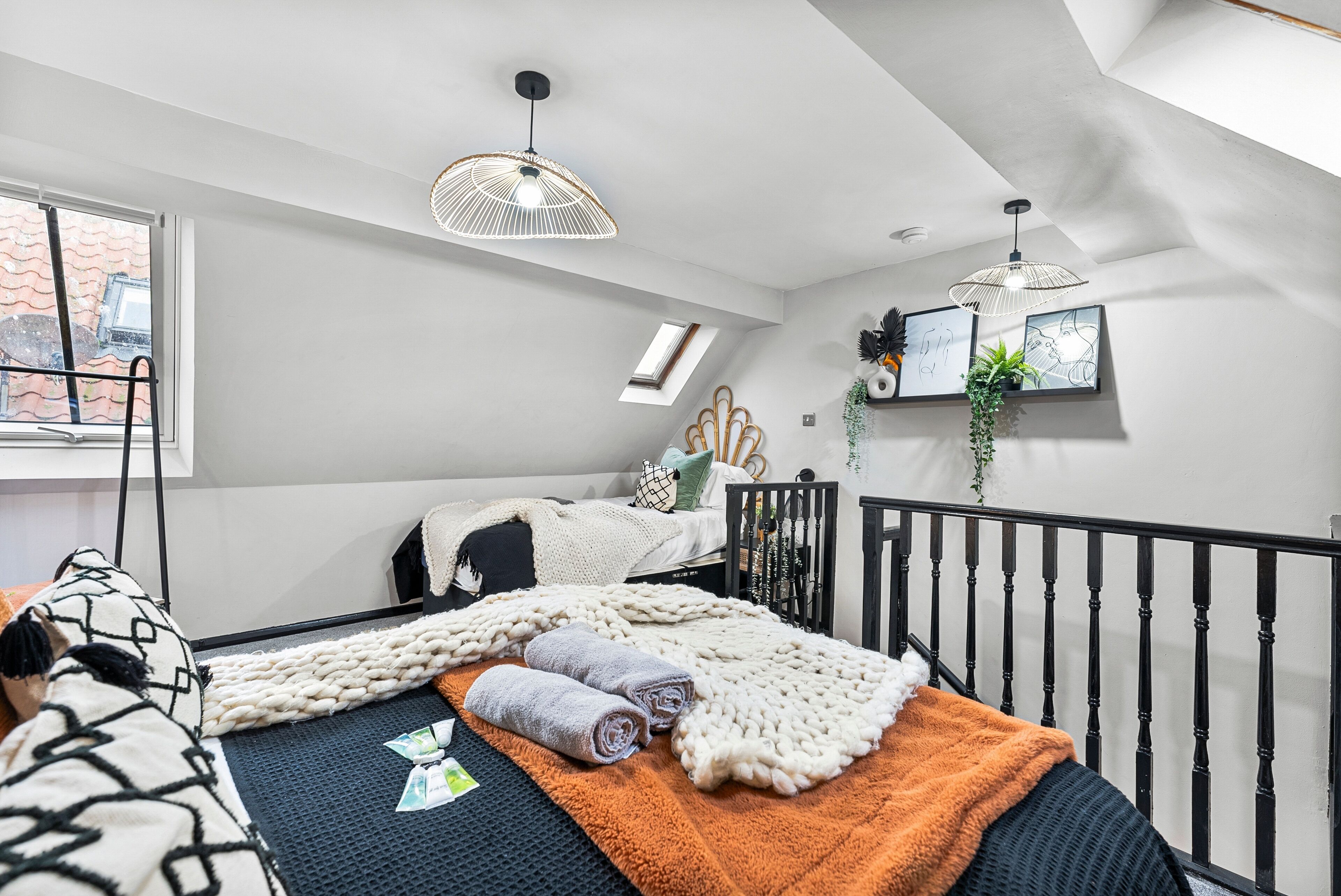 A modern bedroom with a loft bed, a large window, and a view of the city.