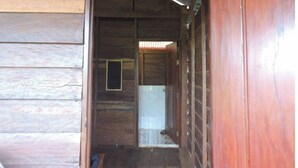A wooden interior with a door leading to a room.