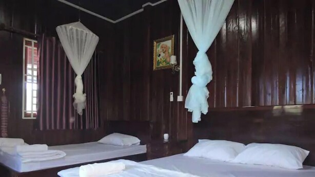 A hotel room with two beds, each with white linens and pillows, a wooden headboard, and a window with curtains. - Banlung Eco-Lodge Tanam(Mountain View) (Krong Ban Lung)