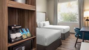 A hotel room with two beds, a coffee machine, a desk, and a window with curtains. - Fairfield by Marriott San Jose Airport Alajuela (Rio Segundo)