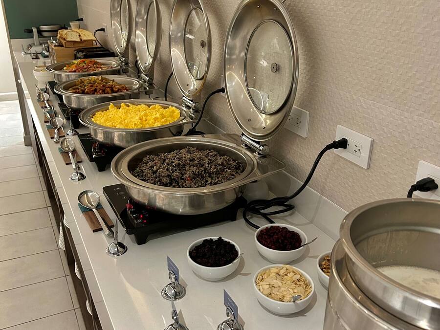 Una mesa de buffet con diferentes platos y utensilios.