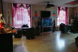 A hotel lobby with a television, seating area, and a Christmas tree.