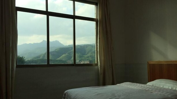 Un dormitorio con un ventanal que ofrece vistas a montañas.