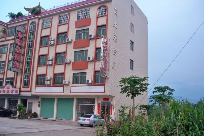 A multi-story building with a commercial ground floor, large windows, and a green awning.