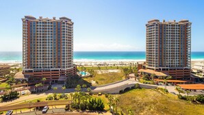 Two high-rise buildings with a beach and ocean view.