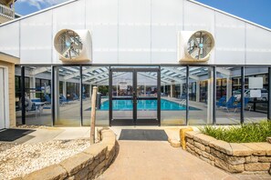 Enter a tranquil oasis with a large glass entrance leading to an indoor pool area.