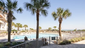 A private property with a swimming pool, palm trees, and a view of the ocean. - Sandcastle Court 219 (Nassau County)