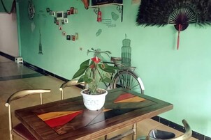 Un comedor con una mesa de madera, sillas y una planta en maceta.