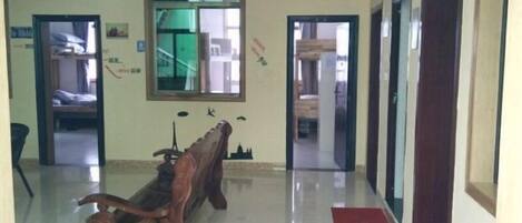 A hallway with a wooden bench, doors, and a mirror on the wall.