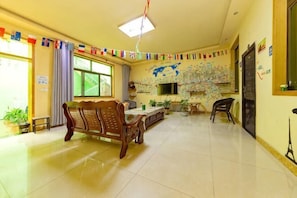 A spacious room with a wooden bench, a dining table, and a TV. - Huashan - Loft Youth Mountain Residence (Huayin)