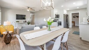 Une cuisine moderne avec des meubles blancs, un four à micro-ondes et un réfrigérateur.