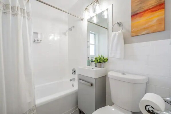 A modern bathroom with a bathtub, a toilet, and a sink.