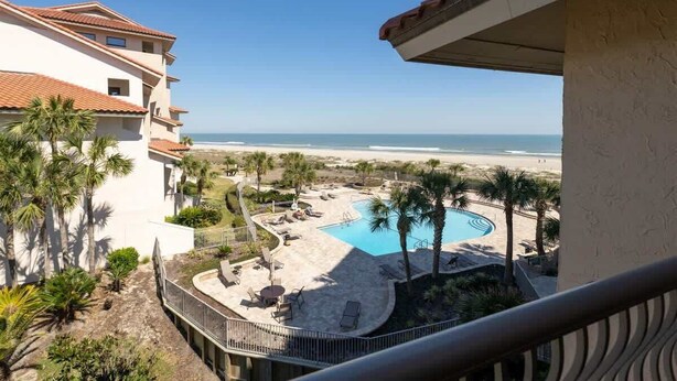 A resort with a pool, palm trees, and a beach view. - Sandcastle Court #220 -Kitchen (Nassau County)